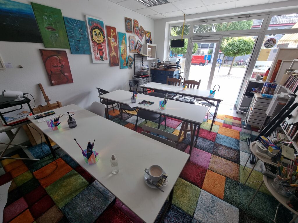 Ansicht des Ateliers mit den Tischen und Stühlen, aufgebaut für die ganzen Kinder, die gleich zum Malkurs in Engelskirchen-Ründeroth erscheinen werden. Auf dem Tisch steht gerade noch mein letzter Kaffee bevor es losgeht.